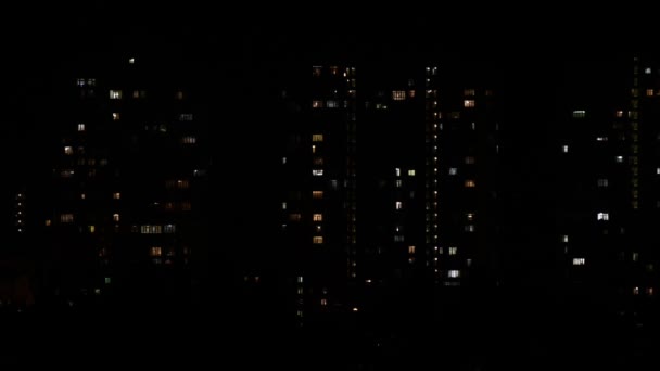 Ночное затишье размытых мигающих огней в окнах многоэтажных зданий в темноте — стоковое видео