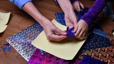 Anne ve çocuk hobi olarak parlak renkli kağıtlarla el sanatları yapıyor.