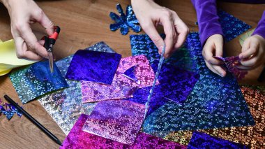 Anne ve çocuk hobi olarak parlak renkli kağıtlarla el sanatları yapıyor.