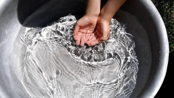 Mãos de criança coletar água limpa em poucos jogos de água jogando — Fotografia de Stock