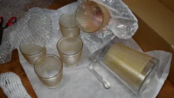 Проміжок часу упаковки скляного посуду в пластикову упаковку з бульбашками та картонну коробку — стокове відео