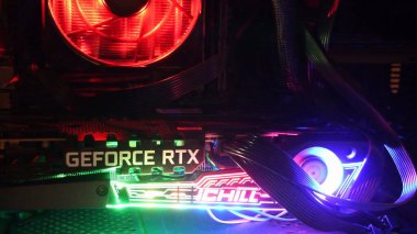 Yakın plan NVidia GeForce RTX 3080 oyun kulesinin içinde, karanlıkta renkli arka ışıkları var.