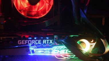 Yakın plan NVidia GeForce RTX 3080 oyun kulesinin içinde, karanlıkta renkli arka ışıkları var.