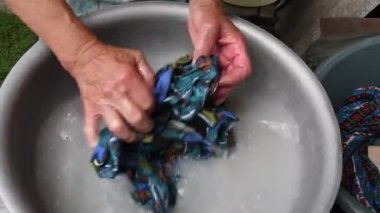 Kırış kırış ellerle çamaşır yıkamak ve 80 yaşında yaşlı bir kadının cildine sahip olmak.