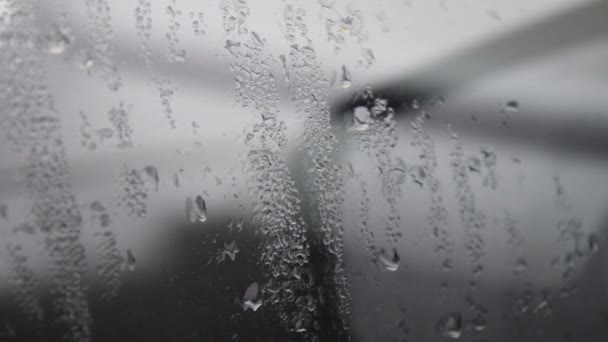 Gotas de chuva no vidro enevoado da janela do carro. Espelho lateral do borrão coberto com condensação de bolhas de água. — Vídeo de Stock