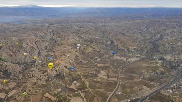 Kleurrijke heteluchtballonnen drijvend over berglandschap in Cappadocia Turkije — Stockvideo