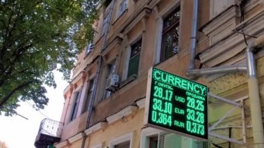 Yanıp sönen yeşil para birimi döviz kuru tahtasıyla eski bina dış arkaplanı