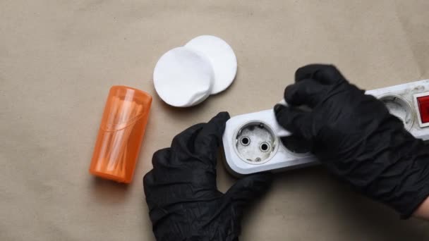 Hände in schwarzen Handschuhen säubern die verschmutzte Plastikverlängerung. Elektrischer Extender reinigen — Stockvideo