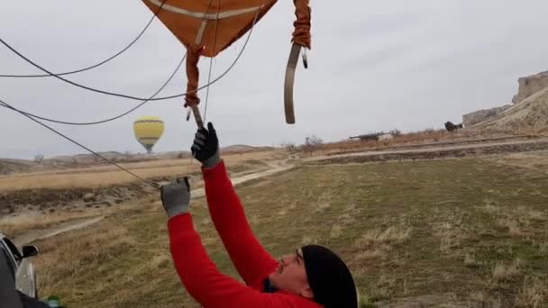 Balonista pilot stáhnout kupoli horkovzdušného balónu na deflační balón po přistání — Stock video