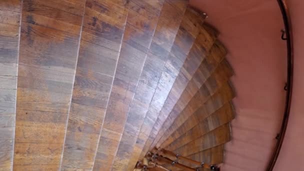Рух вниз по старих дерев'яних спіральних сходах з витонченими перилами і похилими сходами — стокове відео