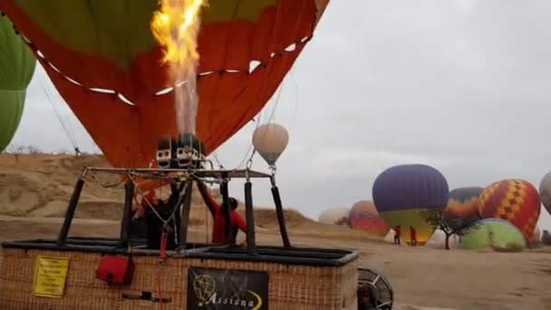 Kara üzerinde duran hasır sepetle balonu şişirmek için sıcak hava balonundan alev alev yanan ateş — Stok video