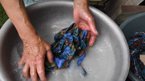 Lavagem à mão por mãos enrugadas de mulher de 80 anos — Fotografia de Stock