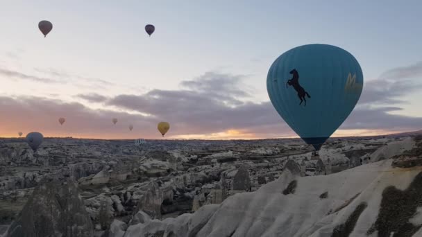 Niebieskie balony na ogrzane powietrze latają nad górskim krajobrazem w Cappadocia Turcja — Wideo stockowe