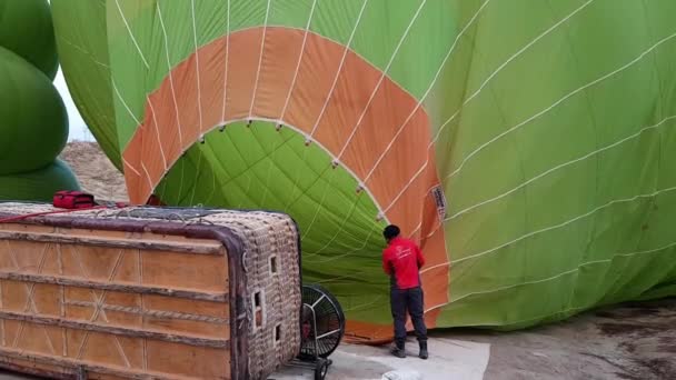 A hőlégventilátor felfújja a hőlégballont Dome fehér fonott kosár feküdt az oldalán a földön — Stock videók