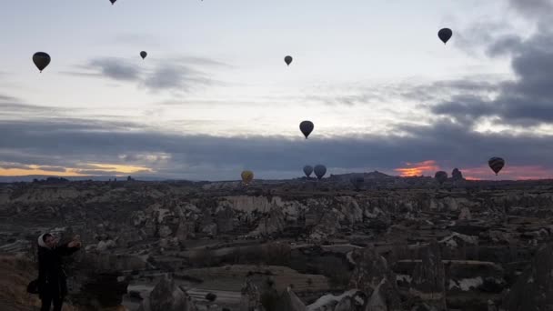 Många varmluftsballonger stiger upp och flyter på himlen över bergslandskapet i Kappadokien Turkiet — Stockvideo