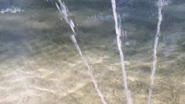 Tiga semburan air yang mengalir di air mancur dengan latar belakang permukaan air yang kabur — Stok Video