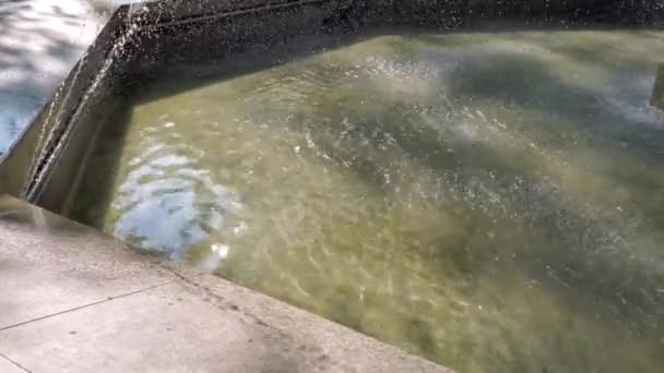 Marmeren fontein rand en rimpel water oppervlak met druppels schijnt in het zonlicht — Stockvideo