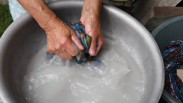 Handwash laundry by wrinkled hands with damaged elderly skin of 80s woman — Stock Photo, Image