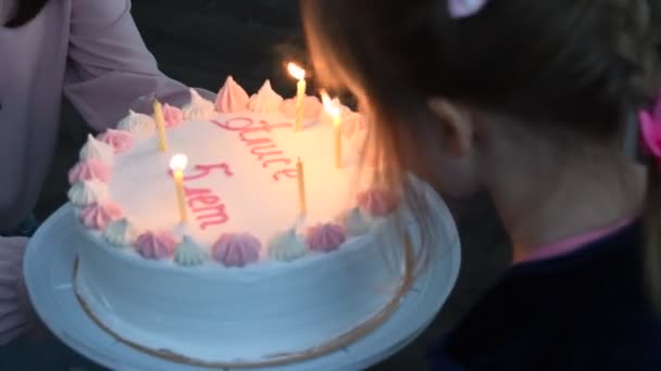 Küçük kızın 5 yaşındaki kutlaması için doğum günü pastasında mum üflediği samimi bir an. — Stok video