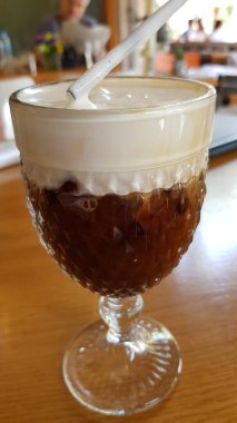 Kapalı kahve kokteyli ve pipet içilen eski şarap bardağı.