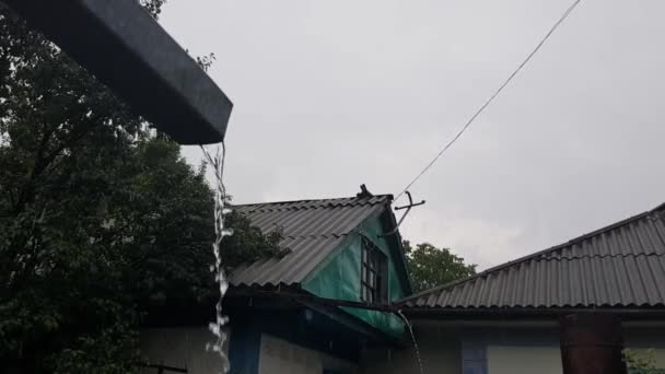 Осінній дощ, що ллється зі старого іржавого жолоба на даху ферми — стокове відео