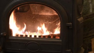 Retro döküm demir koca göbek sobası ve içinde ateş var.