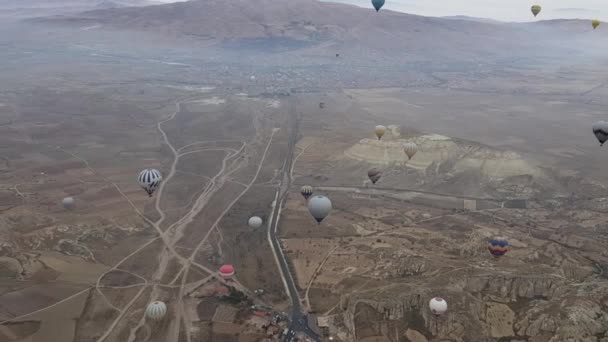 Kleurrijke heteluchtballonnen drijven over berglandschap in Cappadocia Turkije — Stockvideo