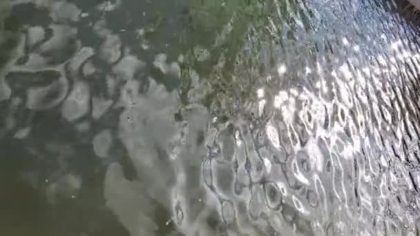Glanzende knipperende zon schittert op glad golvend wateroppervlak van het meer — Stockvideo