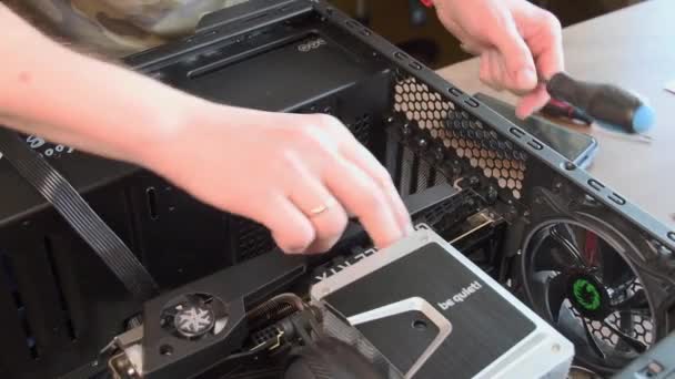 Man handen met schroevendraaier assembleren CPU koeler met NVidia GeForce grafische kaart geïnstalleerd binnen — Stockvideo