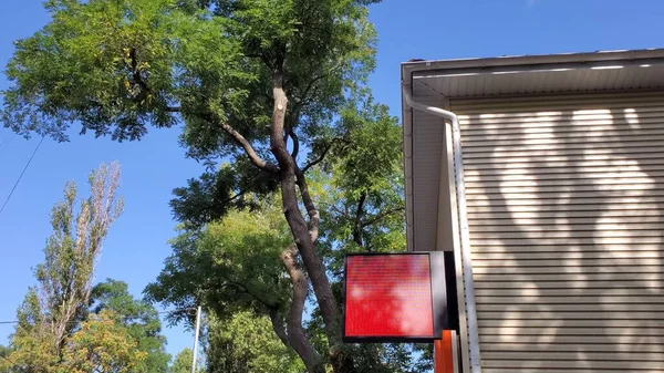 Κόκκινη πινακίδα στο κτίριο τοίχο με θολή σκιά δέντρο — Φωτογραφία Αρχείου