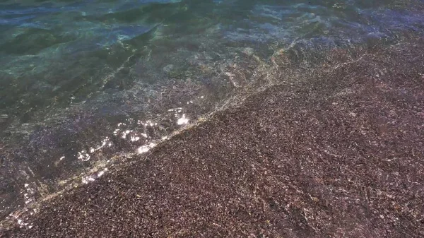 Água transparente que flui para a areia da praia no mar surf — Fotografia de Stock