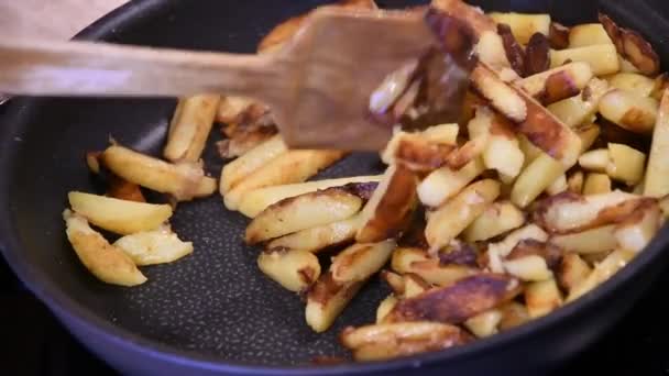 Fritar e mexer batatas fritas caseiras na panela no fogão de cozinha — Vídeo de Stock