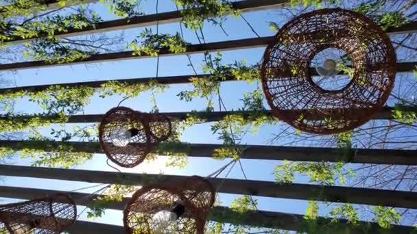 Candeeiros de vime em forma de cesta pendurados no teto de madeira do eixo — Vídeo de Stock