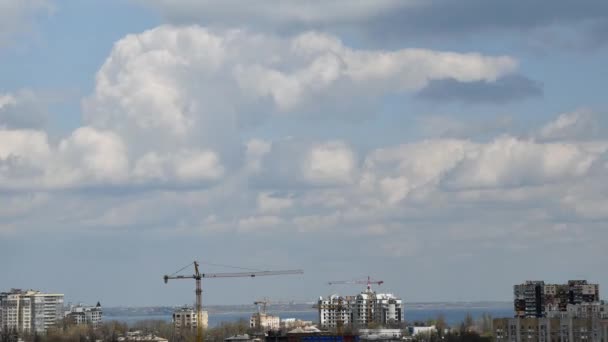 Gru da costruzione su edifici residenziali tetti e time lapse cloudscape — Video Stock