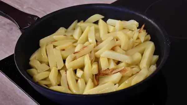 Fritar batatas fritas caseiras na panela no fogão de cozinha — Fotografia de Stock