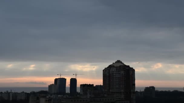 高楼大厦和建筑用起重机的轮廓映衬着乌云密布的天空的城市天际线 — 图库视频影像