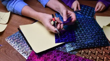 Anne ve çocuk hobi olarak parlak renkli kağıtlarla el sanatları yapıyor.