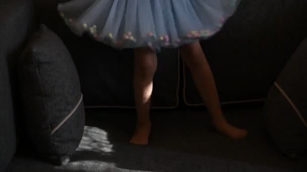 햇볕 이 잘 드는 쇼파에서 뛰고 있는 맨발의 아기 다리 — 비디오