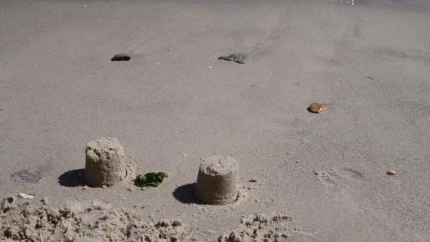 Arena húmeda a la orilla del mar con piedras marinas y arena moldeada, luego los pies de niño la arruinan — Vídeos de Stock