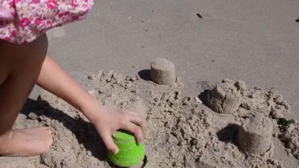 Çocuk kum küf aletinden kumdan kale yapar, sonra onu mahveder ve yeniden yapar. — Stok video
