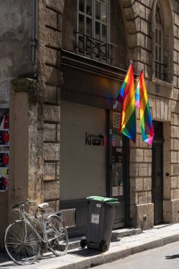 Bisikletli Paris sokağı, antik duvarın yanında LGBTQ bayrakları asılı.