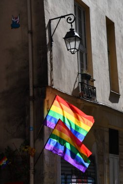 Paris 'teki eski binanın köşesinde LGBTQ bayrakları var. Transseksüel Gurur bayrağı