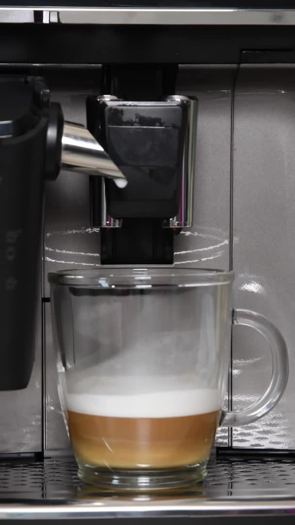 Cafetera vertiendo espresso caliente para preparar café con leche — Vídeos de Stock