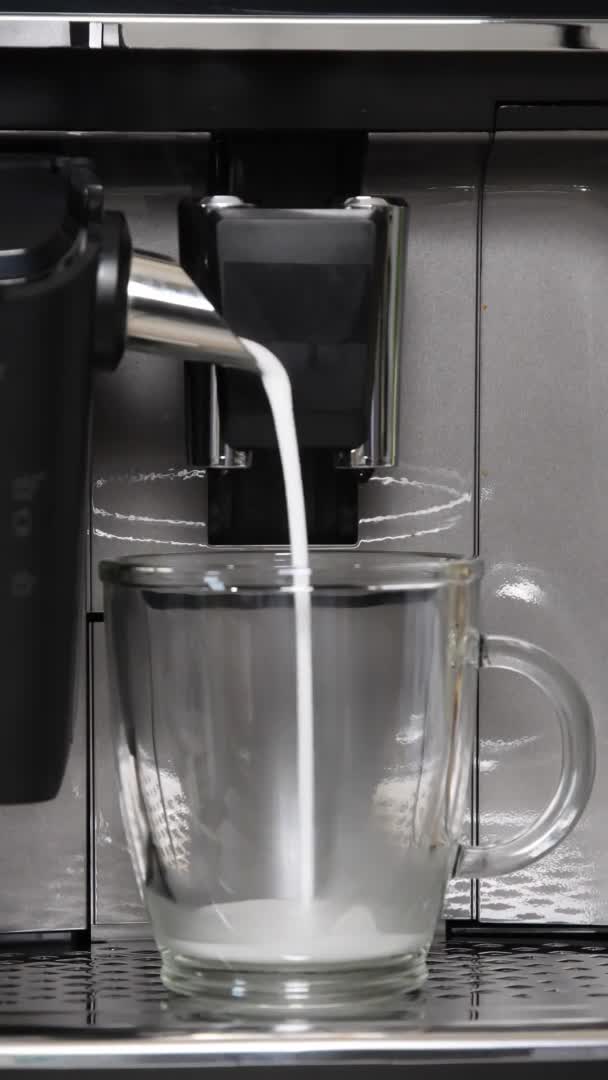 Coffee maker pouring hot milk to prepare coffee with milk froth — Stock Video