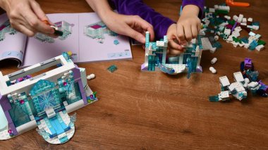 Bebeklerin ve annelerin elleri Lego oyuncakları oynar.