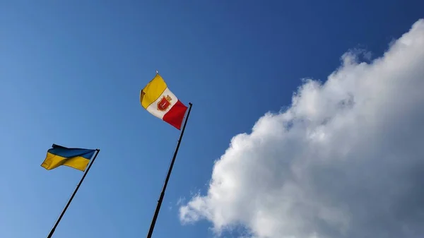 Bandeira ucraniana e bandeira da cidade de Odessa balançando no vento no fundo do céu azul com nuvem branca — Fotografia de Stock