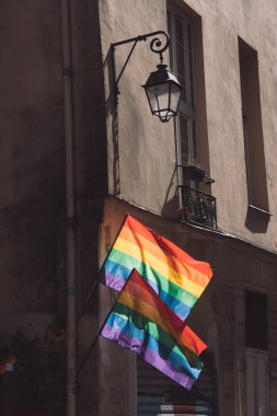 LGBTQ bayrakları ve Paris 'te eski bir binanın köşesinde eski bir fener.