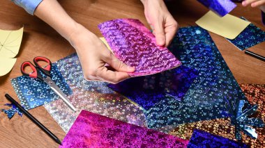 Kadın eli hobisi. Parlayan renkli kağıtlarla el işi.