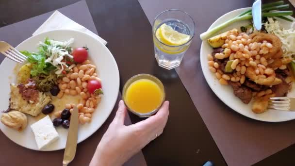 Time lapse persone che mangiano con coltelli e forchette da piatti pieni e succhi di frutta — Video Stock