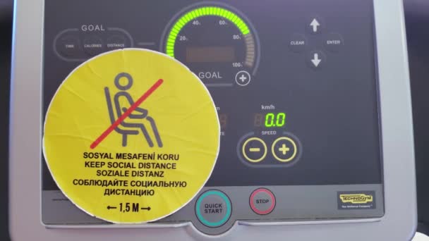 Houd social distance waarschuwingssticker op knipperende digitale weergave van loopband fitnessapparatuur — Stockvideo